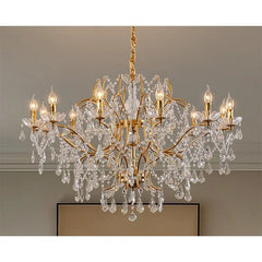 View of a gold chandelier with multiple tiers of crystal beading and cascading pendants, emitting a warm glow.