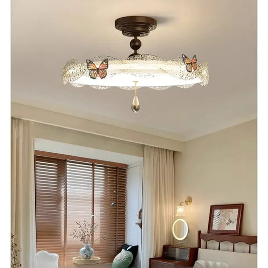 Bronze butterfly drum semi-flush ceiling light with crystal accent, displayed in a bedroom.