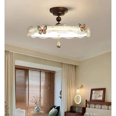 Bronze butterfly drum semi-flush ceiling light with crystal accent, displayed in a bedroom.