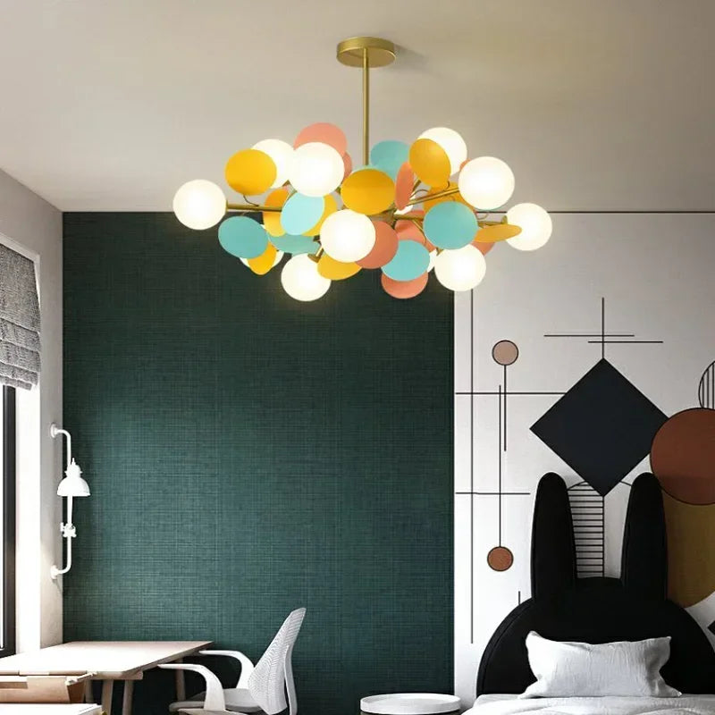 A bedroom featuring a gold starburst chandelier with globe shades.