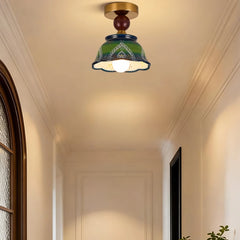 Green ceramic bell pendant light installed on a ceiling in a hallway, showcasing its decorative hand-painted design.