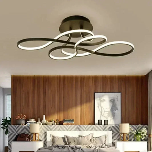 Interior view of a bedroom featuring a black swirl flush mount ceiling light above a bed.