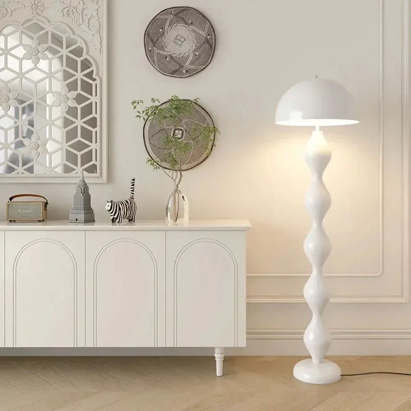 White mushroom floor lamp with a segmented base in a minimalist room.