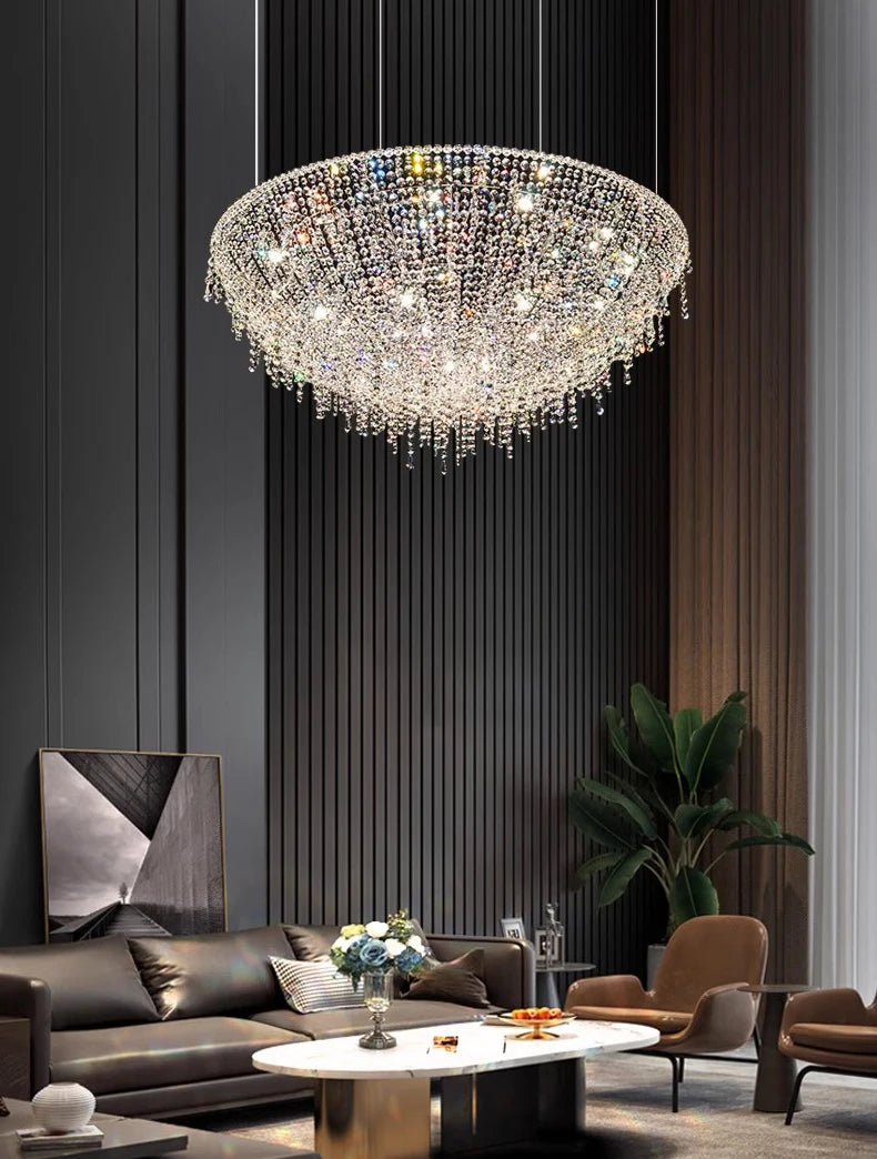 Luxurious chandelier hanging in a modern living room with a dark wall and gray sofa.