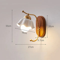 A wall sconce with a white ceramic flower shade, showing dimensions: height 33cm, shade width 18cm, base height 20cm, arm length 27cm, base width 11.7cm.