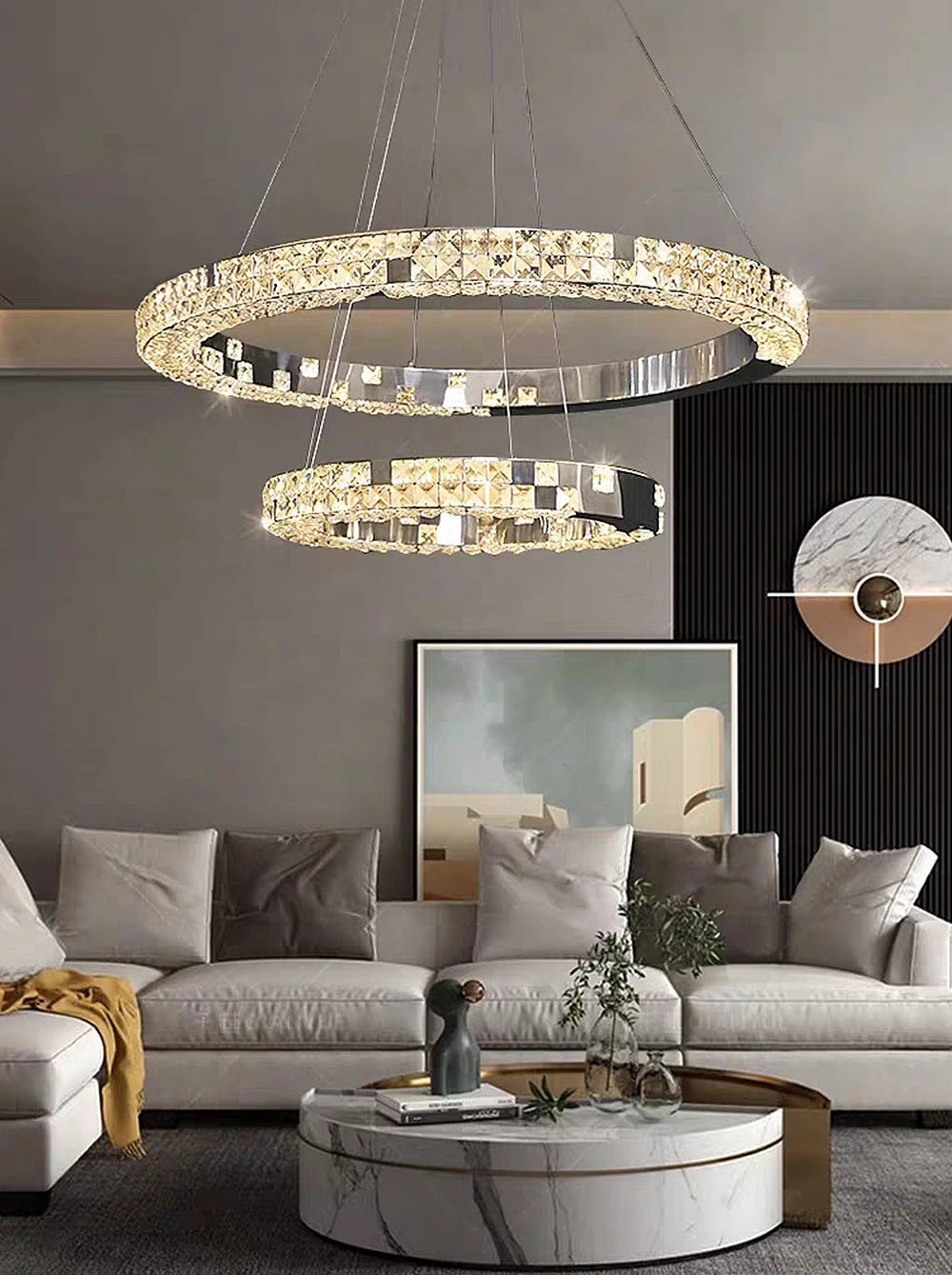 Modern living room with a stylish chandelier, gray sofa, and marble coffee table.