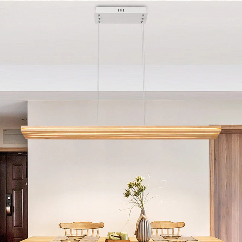 Dining area with wooden chairs, a vase with flowers, and a light fixture on the ceiling.