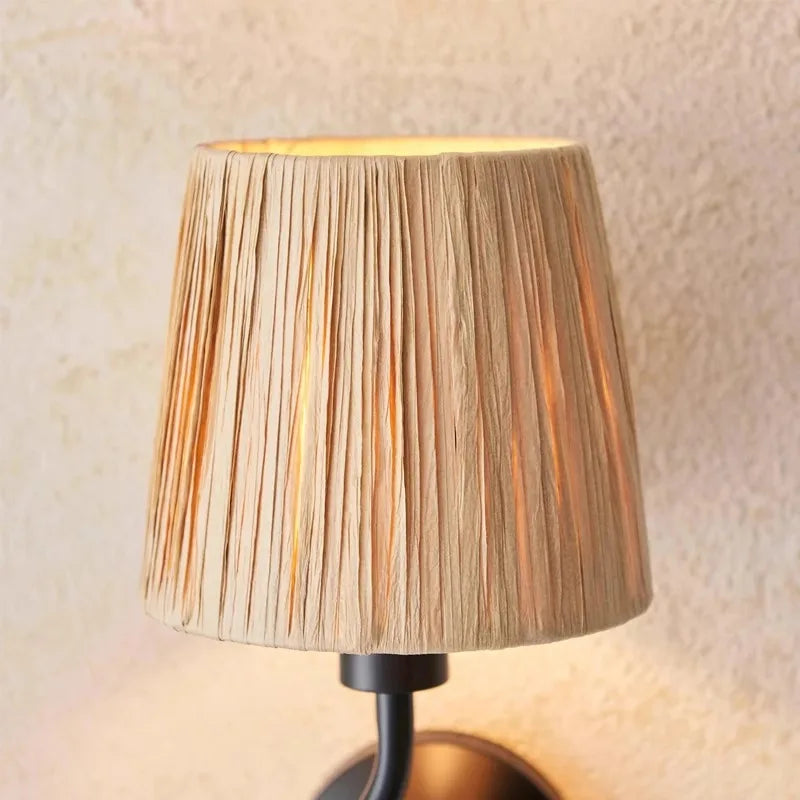 Wall-mounted lamp with pleated beige shade against a neutral wall