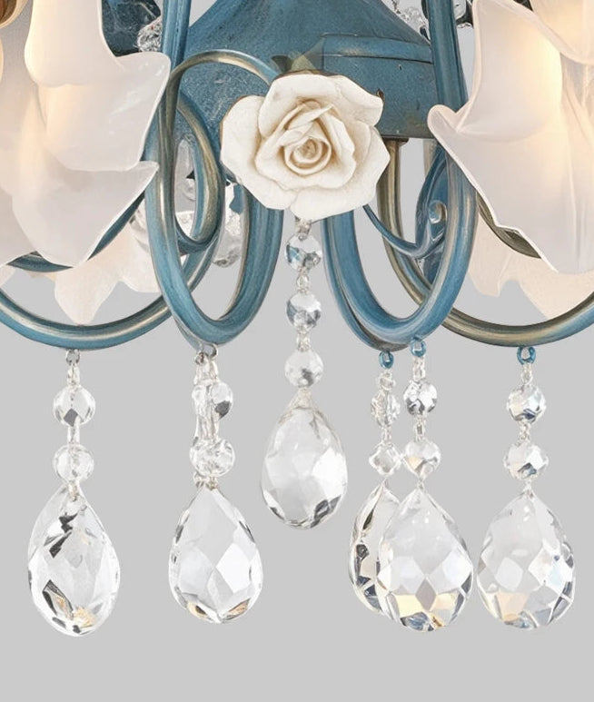 Decorative chandelier with floral design and crystal accents on a light gray background