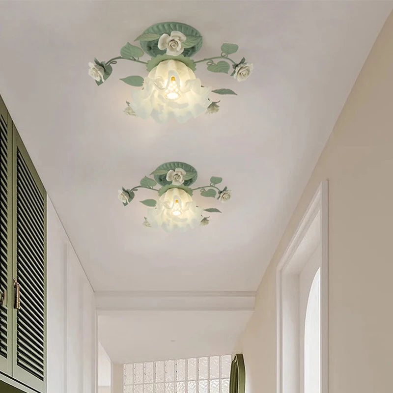 Two green floral flush mount ceiling lights installed on a hallway ceiling, casting a warm glow.
