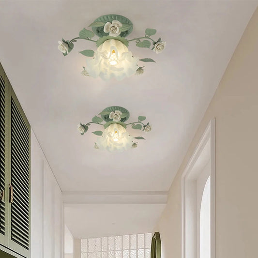 Two green floral flush mount ceiling lights installed on a hallway ceiling, casting a warm glow.
