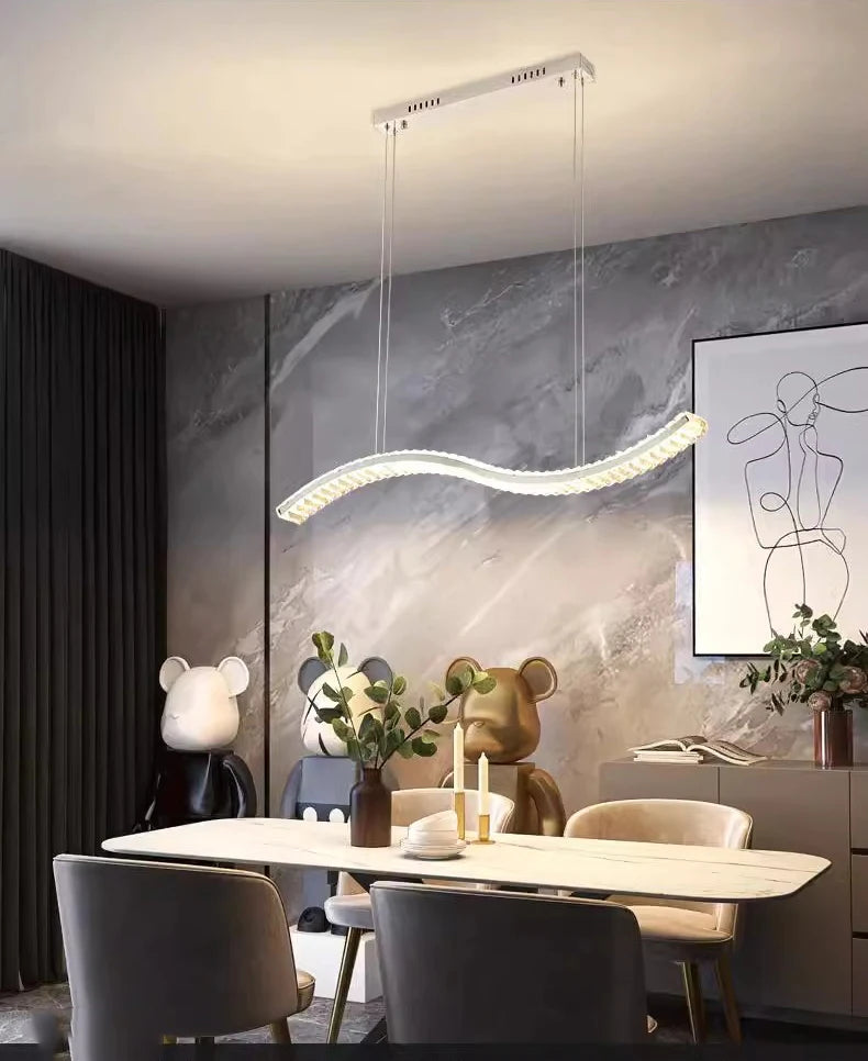 Modern dining room with a hanging light fixture, table, chairs, and decorative elements.