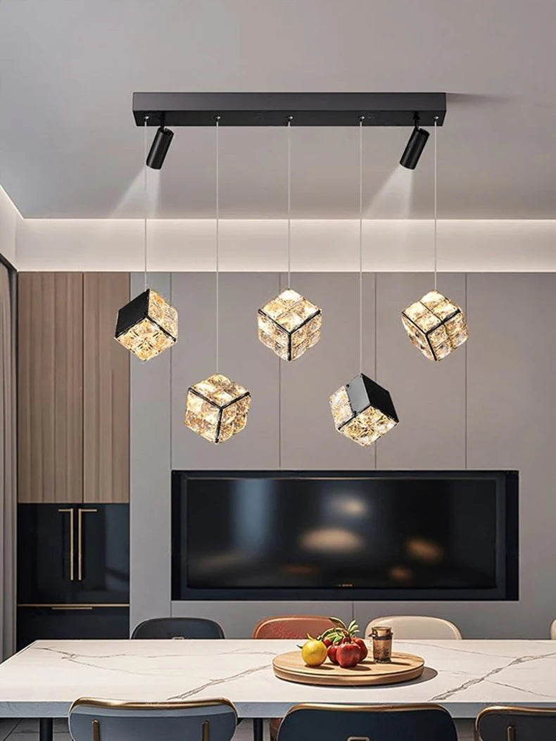 Modern kitchen with pendant lights and a dining table.