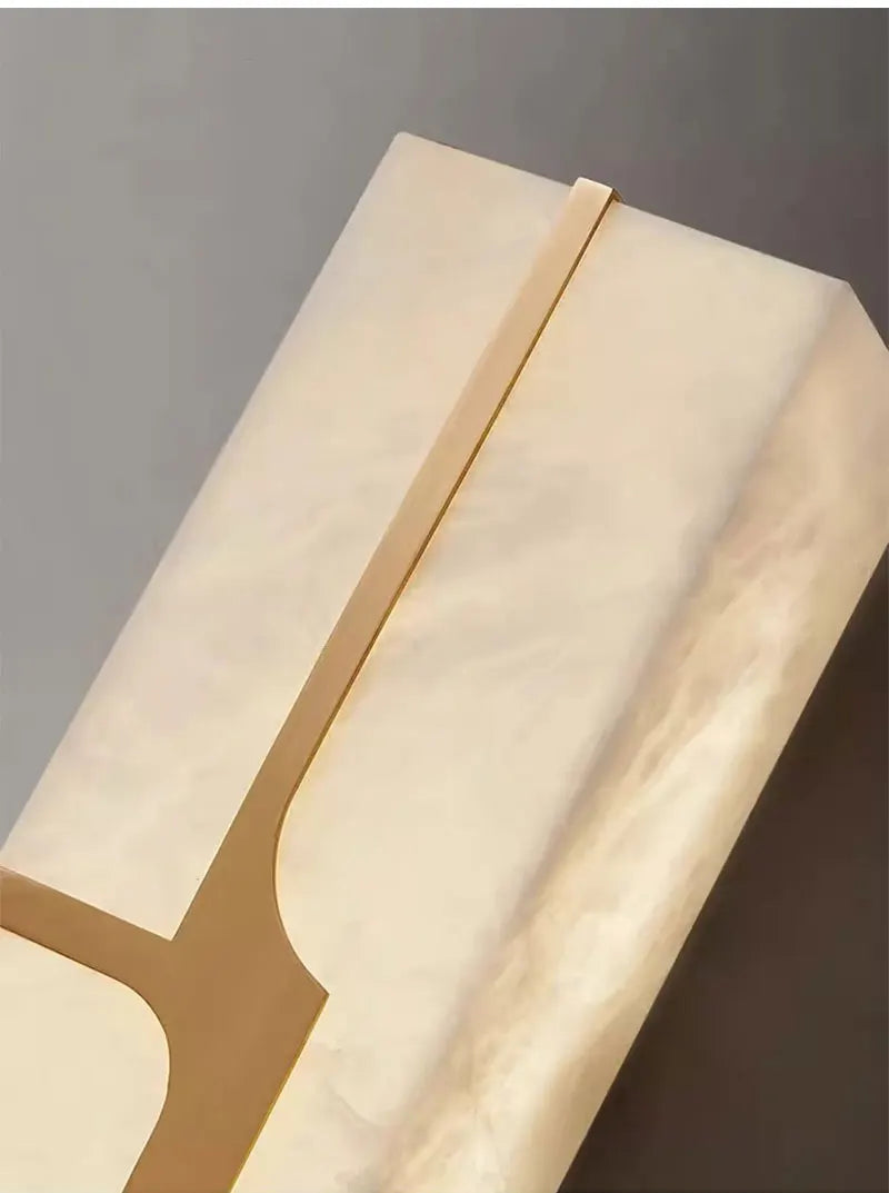 Beige wall sconce with a gold accent on a gray background