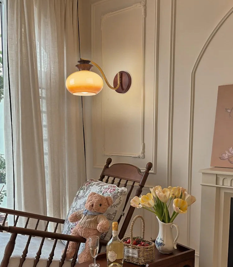 Cozy living room with a teddy bear, wine glass, and flowers on a wooden table.