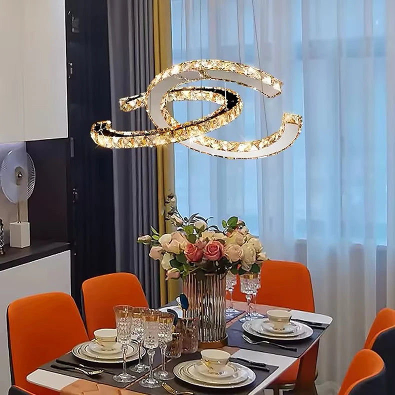 Dining room with a modern chandelier, table set for dinner, and flowers.