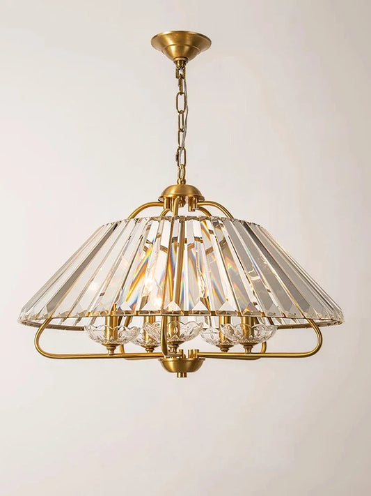 Close-up of a gold crystal faceted pendant light, showing the intricate detail of the crystal and metal frame.