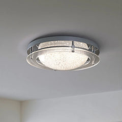 Side view of a chrome flush mount ceiling light, showing its rounded profile against a white ceiling.