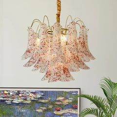Close-up of a gold chandelier featuring bell-shaped glass shades with red speckles, showcasing the intricate design.