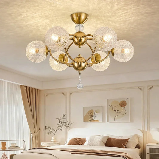 Close-up of the gold semi-flush ceiling light showing the intricate design of the textured glass globes and central crystal.