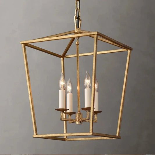 A close-up of a gold geometric cage pendant light with four candle-style bulbs illuminating.