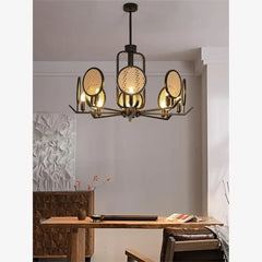 Chandelier with black metal frame and woven rattan discs in a dining room with warm ambient lighting.