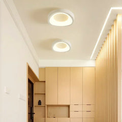 Two white circular flush mount lights with inner glow on a white ceiling