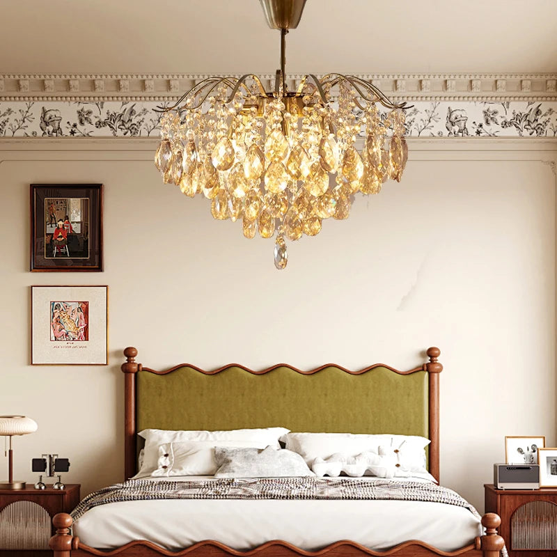 Chandelier hanging above a bed in a bedroom with decorative wall art.