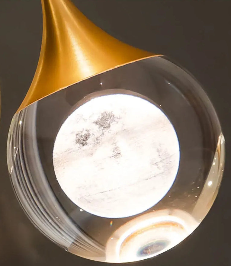 Modern ceiling light fixture with gold and clear design on a dark background