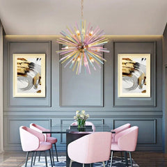 A dining room featuring a large, colorful starburst chandelier hanging over a black table with pink chairs.