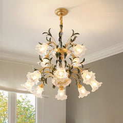 Close-up of a multi-arm gold chandelier with clear glass shades shaped like flowers, hanging from a ceiling.