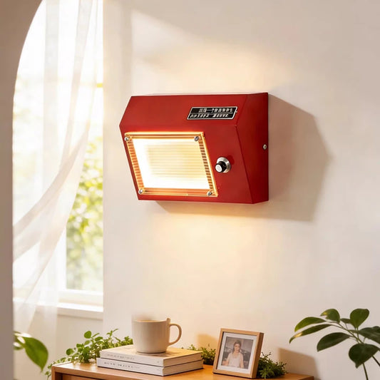 Red retro radio shaped wall sconce mounted on a white wall, with a warm light illuminating the front panel.