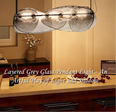 Layered grey glass pendant light in a room setting with decor elements.