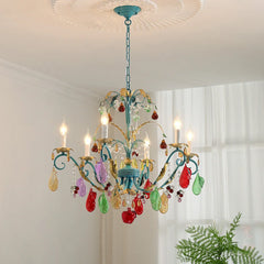 A gold floral fruit crystal chandelier adorned with colorful glass fruit and teardrop crystals, mounted on a white ceiling with a decorative medallion.