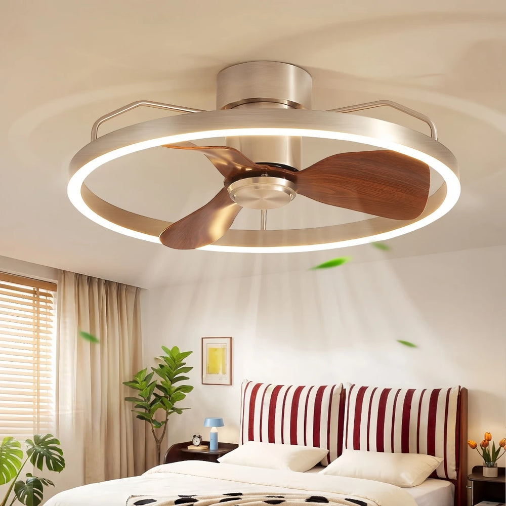 Brushed nickel ceiling fan with a circular LED light and wooden blades, shown in a bedroom setting.
