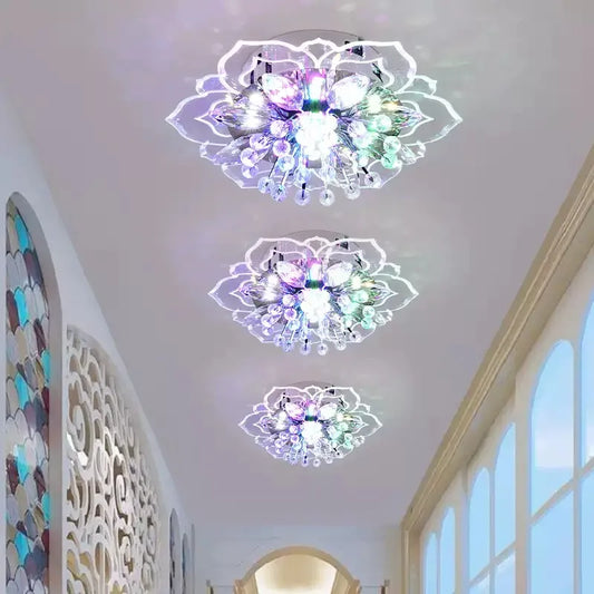 A hallway decorated with three flower-shaped ceiling lights, emitting colorful and white light.