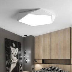 Modern geometric white flush mount ceiling light installed in a bedroom.