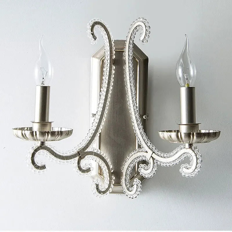 Decorative wall sconce with two candle-style lights on a plain background