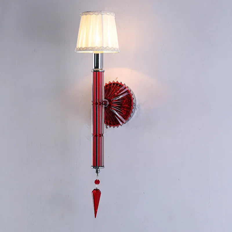 Decorative wall sconce with red and clear glass design on a white background