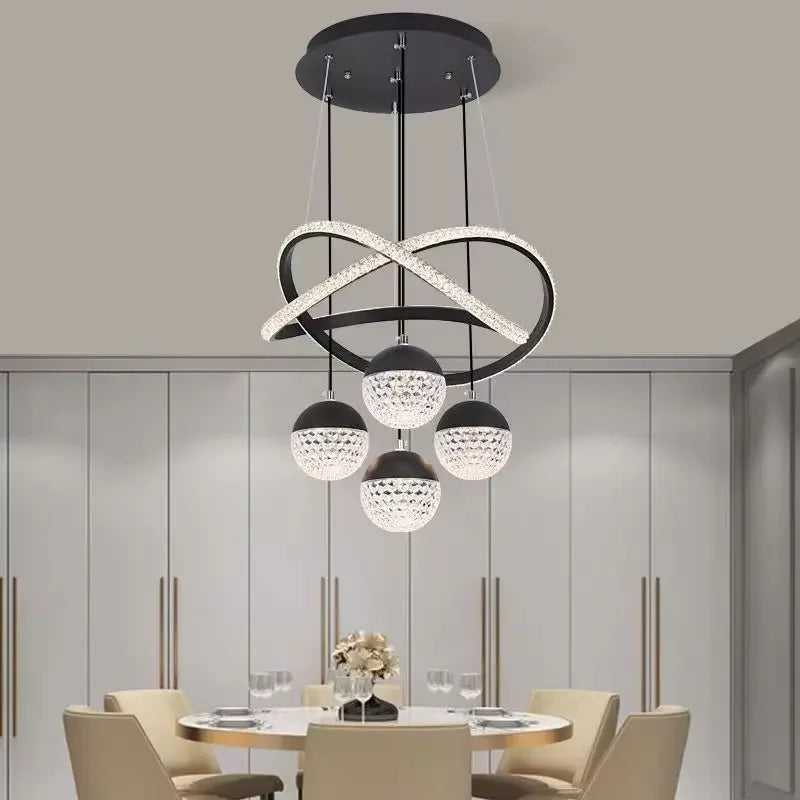 Modern chandelier hanging above a dining table with chairs in a room.