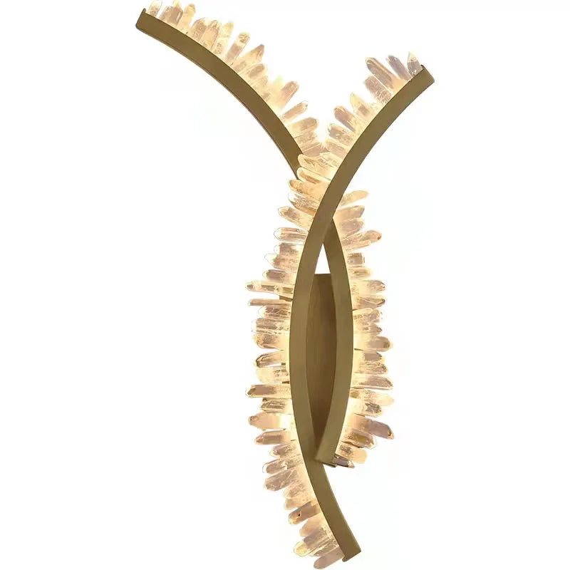 Decorative wall light fixture with gold finish and intricate design on a white background
