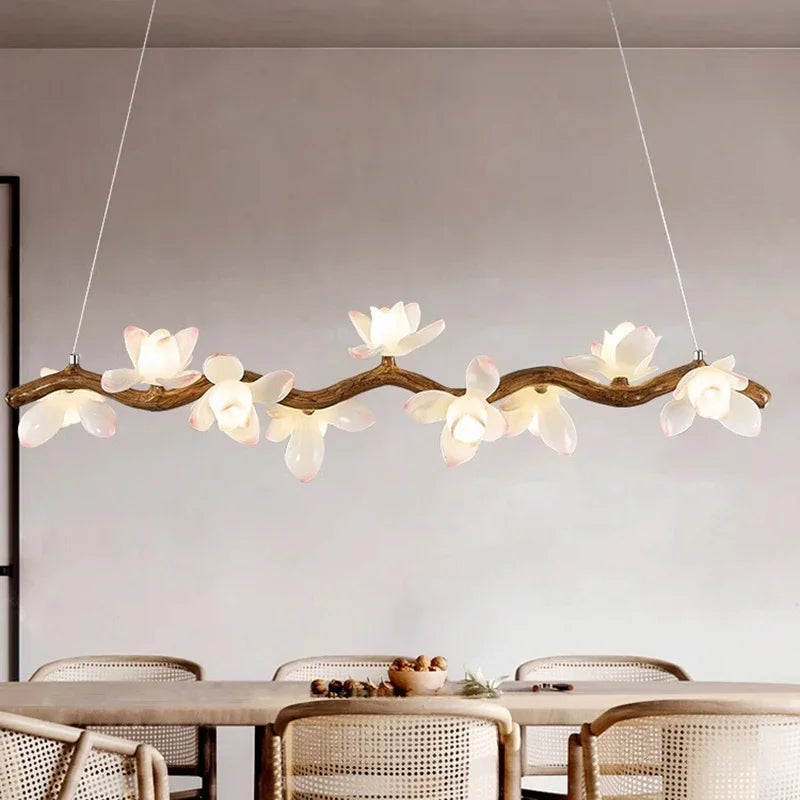 Modern pendant light fixture with floral design hanging above a dining table.