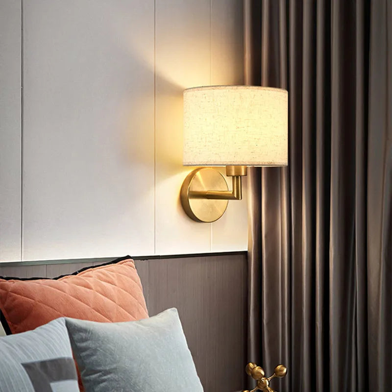 Wall-mounted lamp with a soft glow in a bedroom setting.