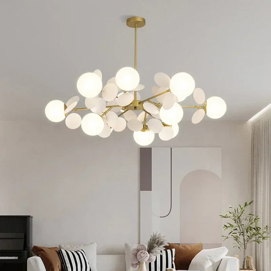 Gold starburst chandelier with multiple white globe lights hanging from a ceiling.