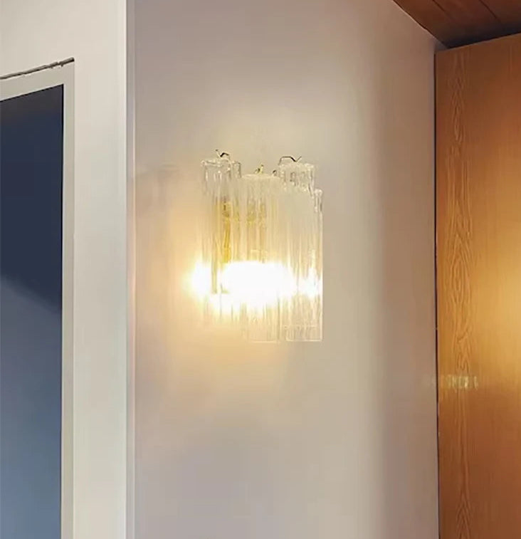 Modern wall light fixture on a white wall with wooden door to the right