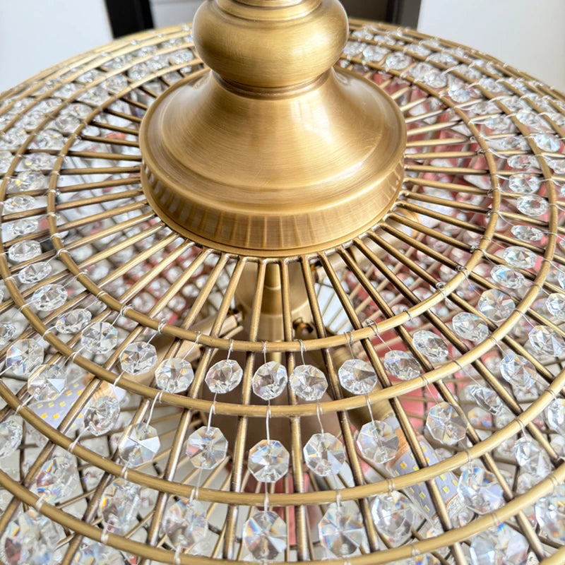Detailed view of the intricate metalwork and sparkling crystals of a large, round chandelier.