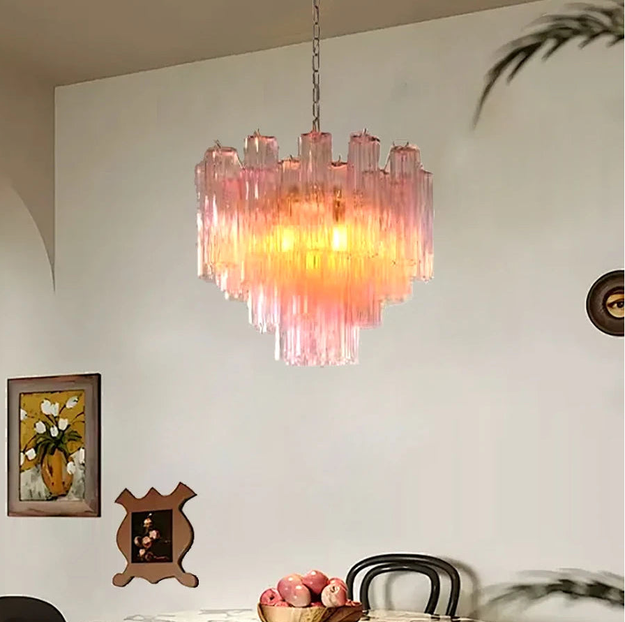 Dining room with a pink chandelier, marble table, and chairs.