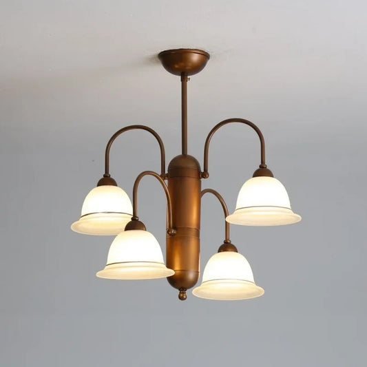 A close-up, low-angle shot of a brushed gold chandelier with four frosted glass bell-shaped shades arranged symmetrically on curved arms, mounted on a white ceiling.