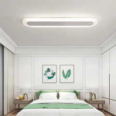 White and grey oval-shaped ceiling light in a bedroom with white paneled walls and green accents.