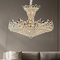 Polished chrome tiered chandelier with cascading crystal and floral accents, illuminated in a living room setting.